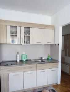 a kitchen with white cabinets and a sink at Apartman Tamara in Zadar