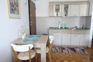 a small kitchen with a wooden table and chairs at Apartman Tamara in Zadar