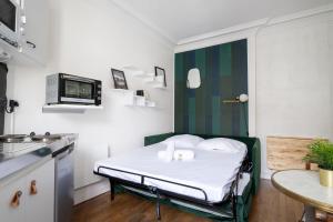 Una pequeña habitación con una cama en una cocina. en Studio Ginoux - Welkeys, en Montrouge