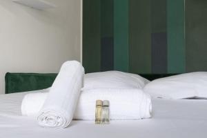 Una cama blanca con toallas y dos zapatillas encima. en Studio Ginoux - Welkeys, en Montrouge