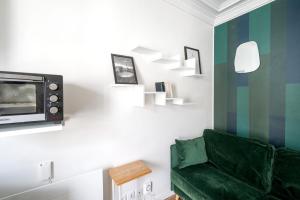 Una sala de estar con un sofá verde y un televisor. en Studio Ginoux - Welkeys, en Montrouge
