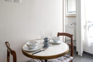 una mesa de madera con 2 sillas y una mesa con copas de vino en Studio Ginoux - Welkeys, en Montrouge