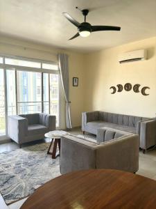 a living room with couches and a ceiling fan at Zanzibar stay manolo in Kiembi Samaki