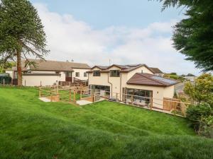 a house with a large yard with green grass at The Bay in Benllech