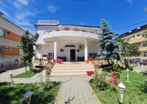 a white building with stairs and flowers in front at Vila turistica UDREA in Eforie Sud