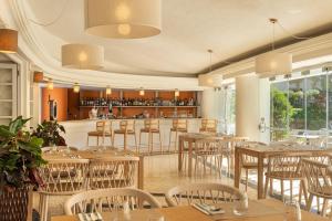a restaurant with tables and chairs and a bar at Balaia Golf Village in Albufeira