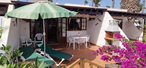 una casa con mesa, sillas y sombrilla en Las Brisas 71, en Playa Blanca