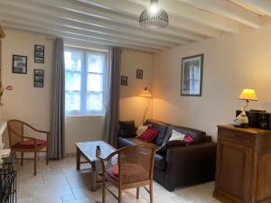 a living room with a couch and a table at Gite les Merlettes in Abbecourt