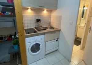 eine Küche mit Waschmaschine und Spüle in der Unterkunft Studio chaleureux à Villarembert, 22 m², proche des pistes in Villarembert + 4 Fotos