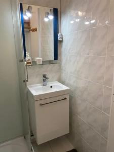 ein weißes Badezimmer mit Waschbecken und Spiegel in der Unterkunft Studio chaleureux à Villarembert, 22 m², proche des pistes in Villarembert