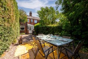 a table with chairs in the garden of a house at No24Sandbach - Exclusive House - Pet Friendly in Sandbach
