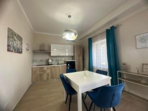 a kitchen and dining room with a white table and blue chairs at Il Rifugio Verde in Caiazzo