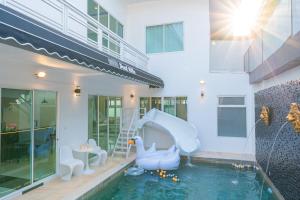 a pool with a water slide in a house at Leon Pool Villa Pattaya in Ban Huai Yai