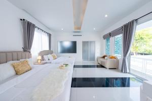 a living room with white furniture and glass floors at Leon Pool Villa Pattaya in Ban Huai Yai