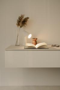 プロブディフにあるHotel Hello Plovdiv - Free Parking and Pet Friendlyのランプと眼鏡が置かれた棚の上の本