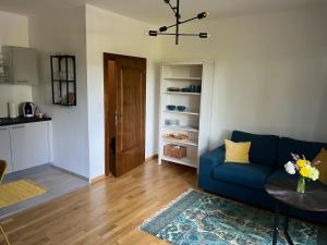 a living room with a blue couch and a table at Appartement Buchenhain in Krumpendorf am Wörthersee