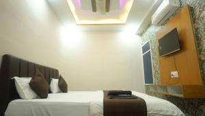 a hotel room with a bed and a tv on the wall at Hotel Mahakal Avantika Palace in Ujjain +68 photos