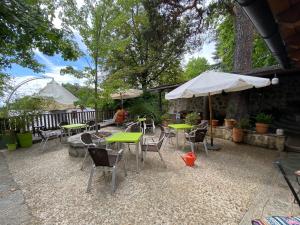 a patio with tables and chairs and an umbrella at Espacio Rural Los Castaños in Cercedilla
