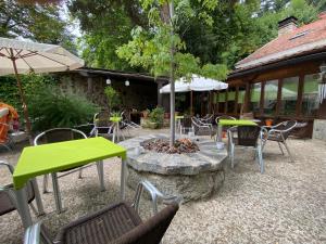 a patio with tables and chairs and a tree at Espacio Rural Los Castaños in Cercedilla