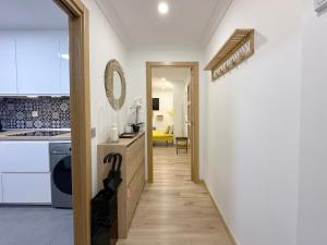 a hallway leading to a kitchen with white walls at Encantador Apartamento junto al Ayuntamiento in Bilbao
