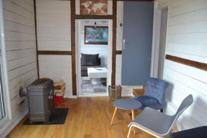 a room with a trash can and a table and chairs at Chalet en Bois Unique Séjour Inoubliable Face à la Mer in Plérin