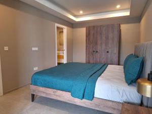 a bedroom with a bed with a blue blanket on it at Kololi Sands Apartments in Kololi