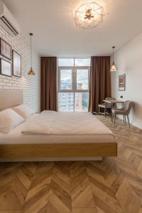 a bedroom with a large bed and a table at Design Apartments with Panoramic View in Kyiv