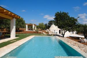 ein Swimmingpool in einem Hof mit einem Haus in der Unterkunft Borgo dei trulli Fanelli in Castellana Grotte