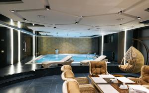 a large swimming pool with chairs and a couch at Ametist Hotel Complex in Samarkand