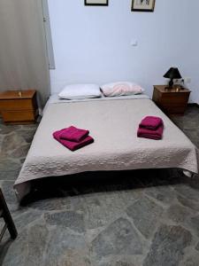 a bedroom with a bed with pink towels on it at Studio Villa Emeli, close to beaches and downtown in Porto Heli