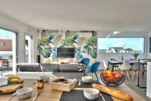 una sala de estar con un sofá y una mesa en Villa ELISA Piscine Intérieure partagée chauffée à 29 degrés à 100m de la plage, en Sibiril