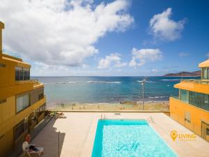 Una vista de una piscina y el océano. en Living Las Canteras Homes - Seaview, en Las Palmas de Gran Canaria