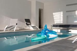 a swimming pool with a blue shark in the water at Villa ELISA Piscine Intérieure partagée chauffée à 29 degrés à 100m de la plage in Sibiril