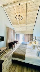 a large bedroom with a large bed and a chandelier at Swakopmund Sands in Swakopmund