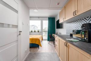 een keuken met een bed in een kamer bij Chill Apartments Pileckiego in Warschau