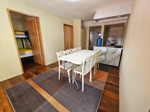 a kitchen and dining room with a white table and chairs at The Catolico's 2 bedroom Transient in Baguio