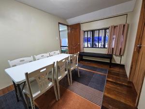 a conference room with a table and chairs and a window at The Catolico's 2 bedroom Transient in Baguio