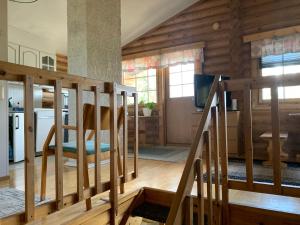 a living room with wooden walls and wooden stairs at Mökki Leskelä Taivalkoski in Taivalkoski