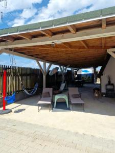 a patio with chairs and a swing and a dog at Bunloc House in Braşov