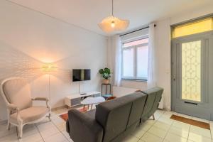 ein Wohnzimmer mit Sofa, Sesseln und Fernseher in der Unterkunft Maison 3 chambres rénovée, proche centre-ville in Marcq-en-Baroeul