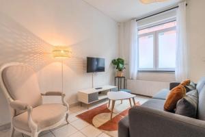 ein Wohnzimmer mit Sofa und Fernseher in der Unterkunft Maison 3 chambres rénovée, proche centre-ville in Marcq-en-Baroeul