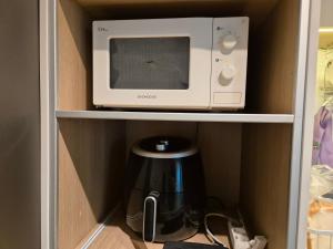 a microwave oven sitting on a shelf next to a coffee maker at MIN Stay - Woman Only Homestay in Seoul