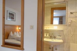 a bathroom with a sink and a mirror and a bed at Chalet Paznaun in Kappl +46 photos