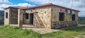 a stone house on top of a hill at Casas Rurales Racha Rachel, Zarza la Mayor in Zarza la Mayor
