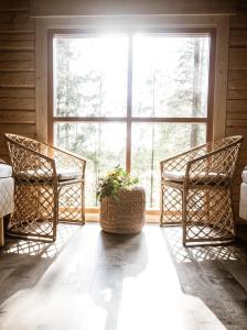 two chairs in a room with a large window at Forest Cabin Ainola next to Nuuksio National Park, in addition Hot Tub and Breakfast in Otalampi
