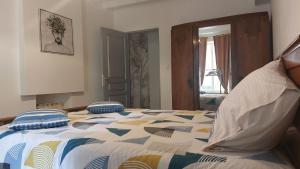 a bedroom with a bed with a colorful comforter at Maison de campagne proche des Châteaux et Beauval in Selles-sur-Cher