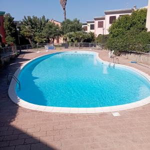 a large swimming pool with blue water at Casa Luca ai Borghi di Villasimius in Villasimius
