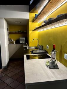 a kitchen with yellow walls and a counter with a sink at PortAllegra Charme&Relax in Bergamo