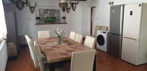 a kitchen with a wooden table and a white refrigerator at Leśne ZACISZE in Świerzno