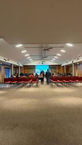 a large room with red chairs and a large screen at Hotel y Cabañas Le Village in San Martín de los Andes